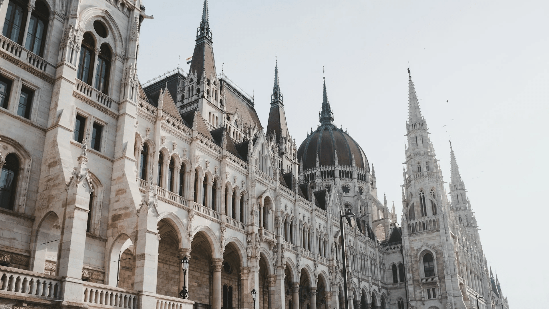 European parliamentary architecture, ornate stone facade with spires and a dome.