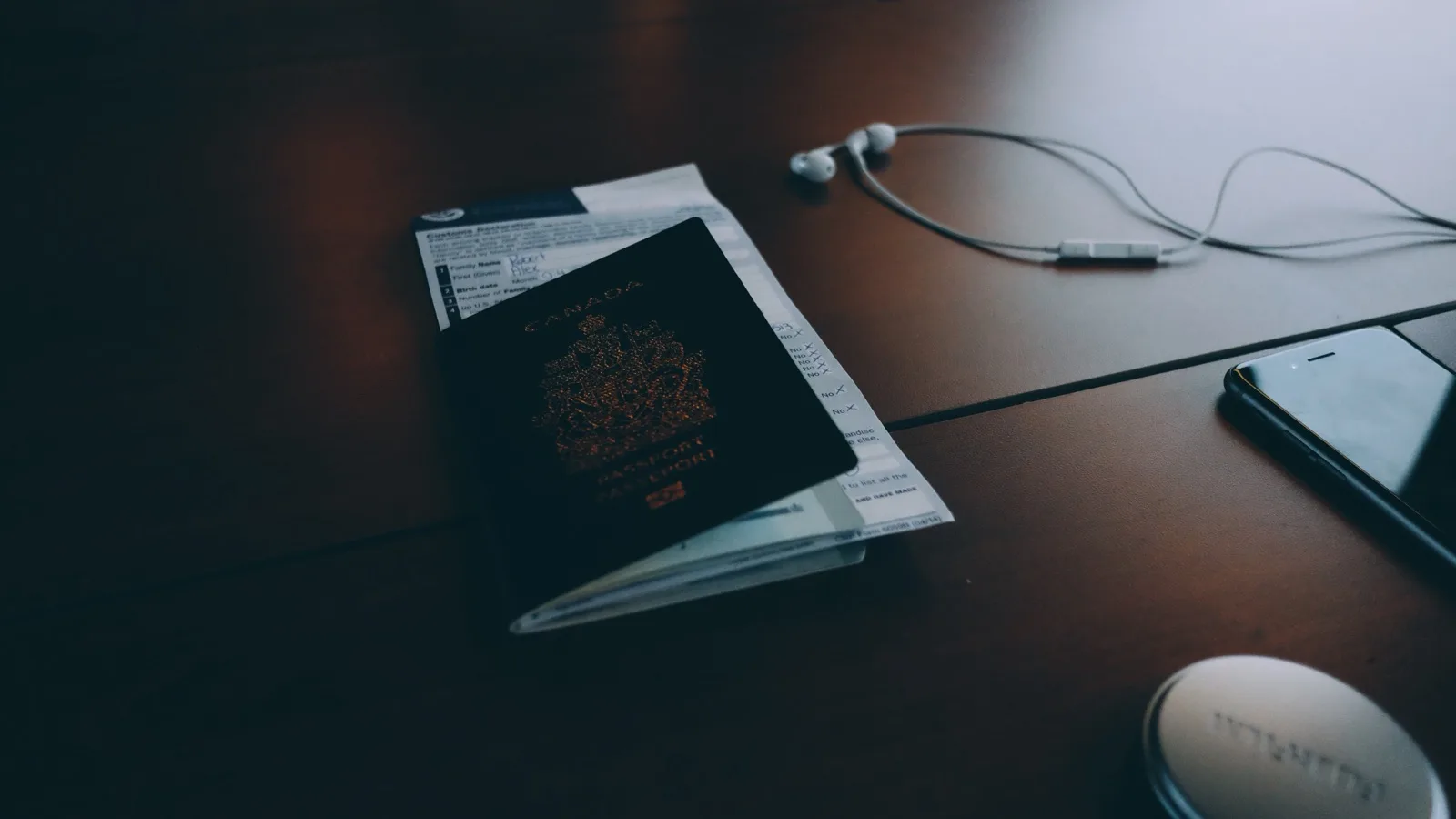 Passport, client documents, phone, and headphones on a dark desk for secure lawyer-client messaging.